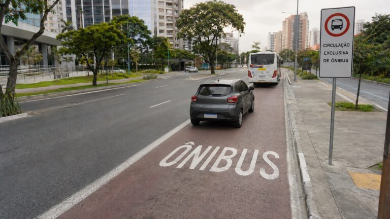 Carro cruzando faixa de ônibus para acessar garagem