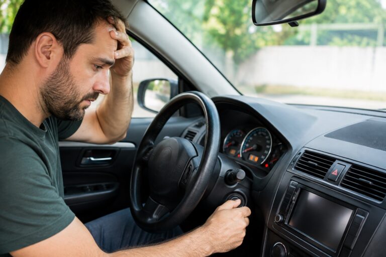Motorista tentando dar partida em carro que não liga.